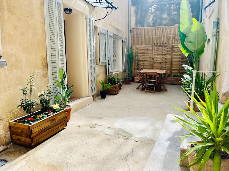 une cour avec des plantes et une table dans un bâtiment dans l'établissement Le Séduisant T2/terrasse, Notre Dame de la Garde, à Marseille