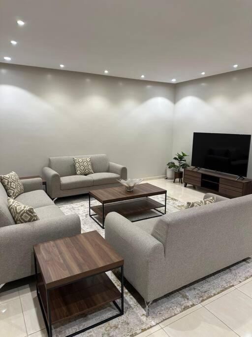 Il comprend un salon avec des canapés et une télévision à écran plat. dans l'établissement وحدة سكنية فاخرة 2 Luxury residential unit, à Médine