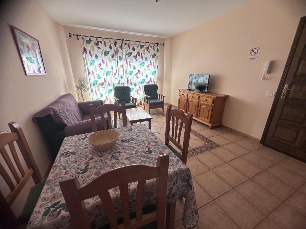 sala de estar con mesa, sillas y sofá en Apartamento vacacional Fuerteventura 1A, en Cotillo