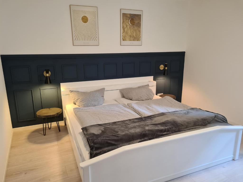 a bedroom with a white bed with a black headboard at FeWo Alt Beilstein in Beilstein
