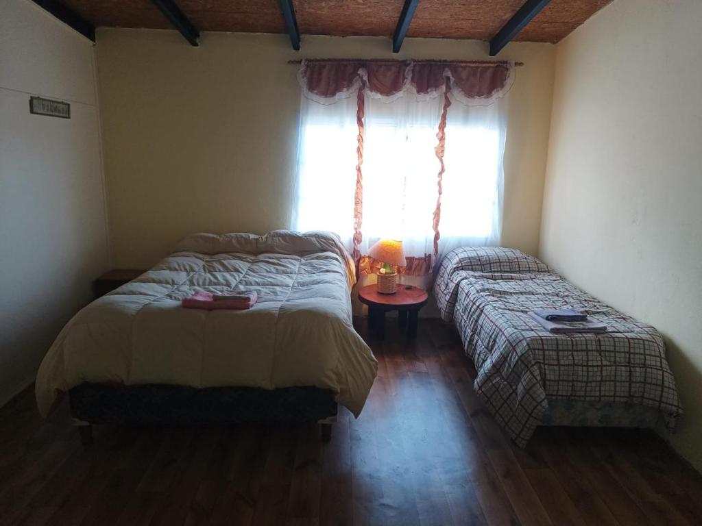 a bedroom with two beds and a window at Alojamiento turístico NFG in San Carlos de Bariloche