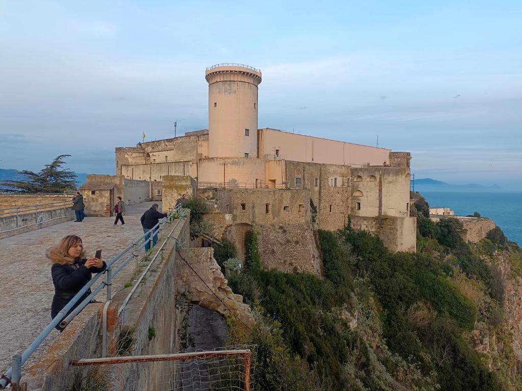 Kobieta robi zdjęcie zamku. w obiekcie Country House Gaeta w mieście Gaeta