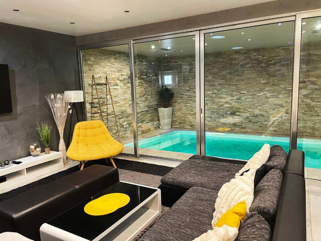 sala de estar con sofá y piscina en Appartement Standing piscine intérieur privatisée ., en Mutzig