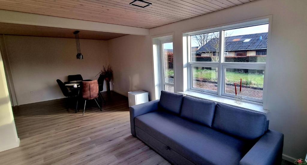 a living room with a blue couch and a table at Annes Hus in Rødekro