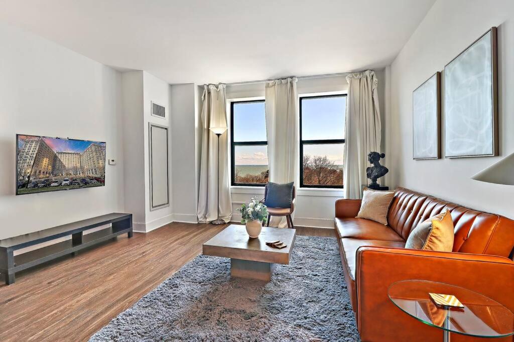 a living room with a couch and two windows at 1BR Chic & Elite Apt in Hyde Park - Shoreland 714 in Chicago