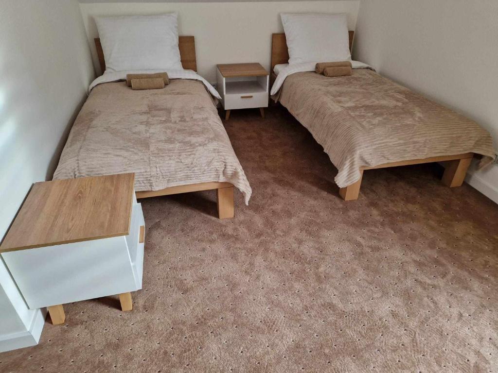 duas camas sentadas uma ao lado da outra num quarto em Noclegi Nad rzeką Białą em StrÃ³Å¼e