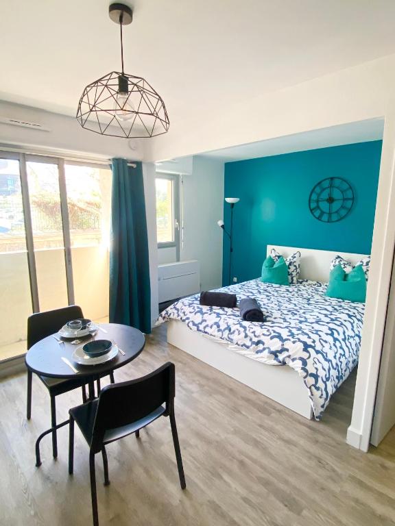 une chambre avec un lit, une table et une chaise dans l'établissement Le Tranquillou, à Sète