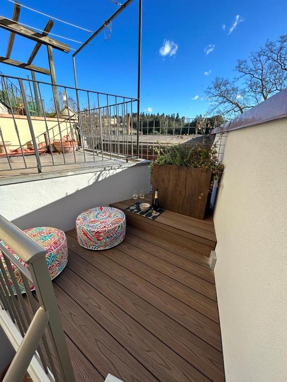 un balcone con 2 sgabelli su una terrazza in legno di Rifugio99 Firenze - Giardini di Boboli a Firenze
