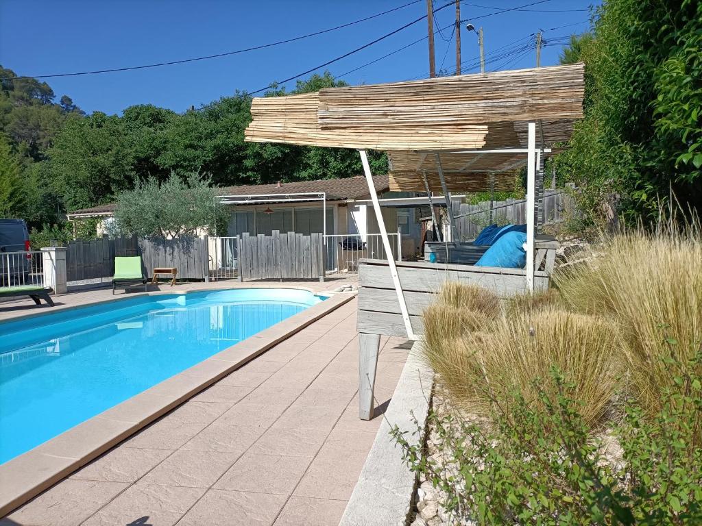 une pergola en bois installée à côté d'une piscine dans l'établissement gîte en provence, à Peypin