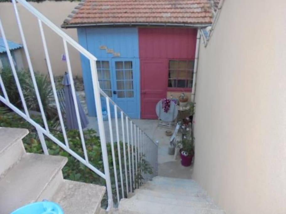 une petite maison avec une maison rose et bleue dans l'établissement Fabienne côté jardins de la fontaine, à Nîmes