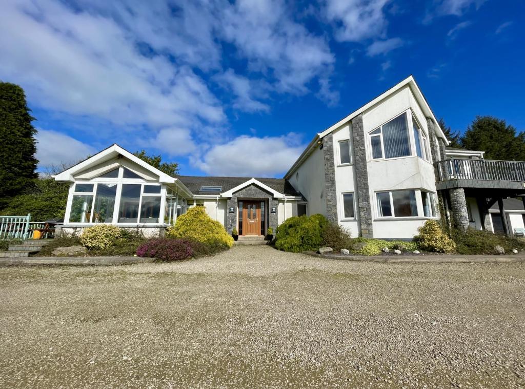 a large white house with a driveway at Lackandarralodge large 5BR entire house sleeps14! in Dungarvan