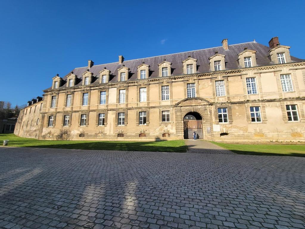 a large building with a cobblestone street in front of it at Château des Princes " Fleur de Lys " in Sedan