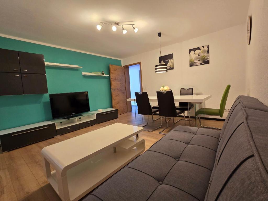 ein Wohnzimmer mit einem Sofa und einem Tisch mit Stühlen in der Unterkunft FeWo Regenbogen in Friedrichshafen