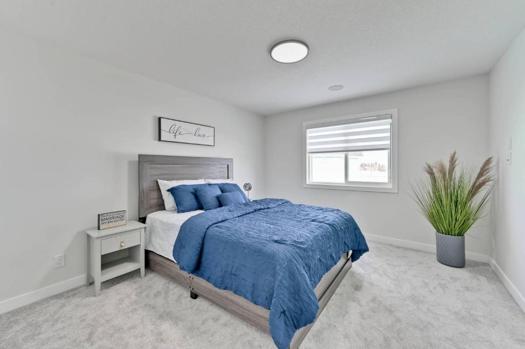 a white bedroom with a bed and a window at Sunny Perch Stay in Edmonton