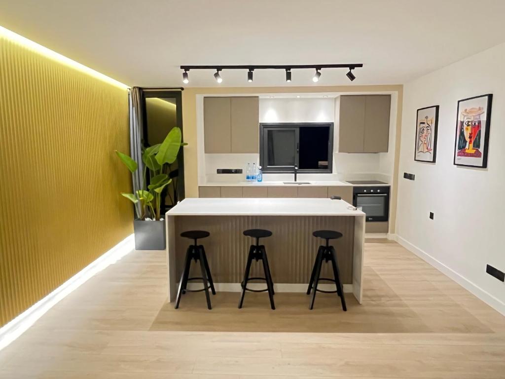 une cuisine avec un comptoir blanc et des tabourets dans l'établissement Modern 2bed in the centre, à Nicosie