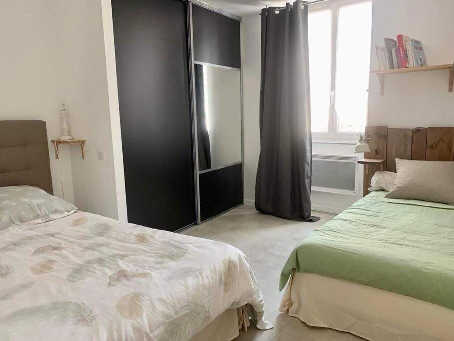 une chambre avec deux lits et une fenêtre dans l'établissement Maison de ville très lumineuse au centre ville, à Dax