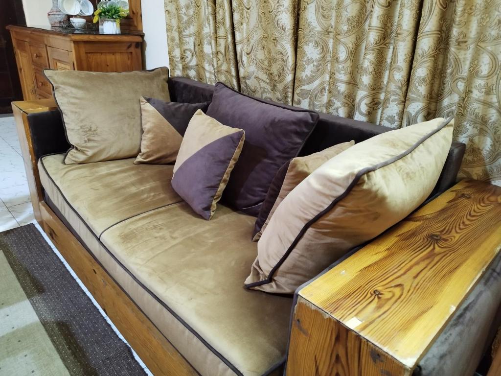 brązowa kanapa z poduszkami i drewnianym stołem w obiekcie Sen Keur Studio w mieście Dakar
