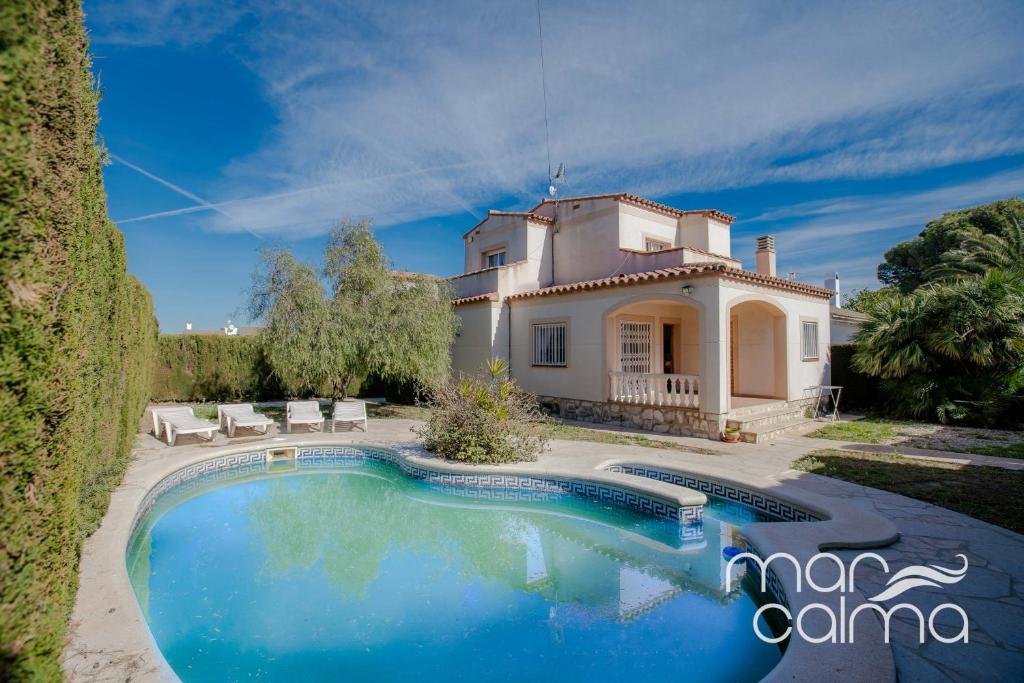 a house with a swimming pool in front of it at Villa Dolce Relax by MarCalma in Les tres Cales