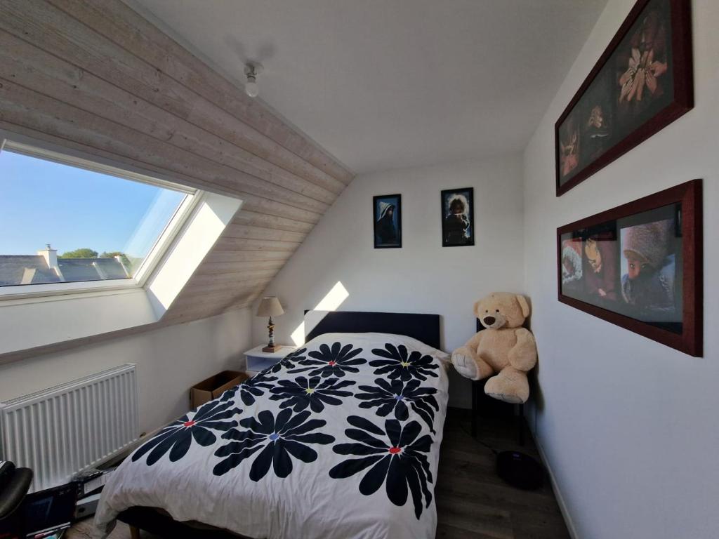 a bedroom with a bed and a teddy bear at Chambre en centre ville proche mer in Saint-Pol-de-Léon