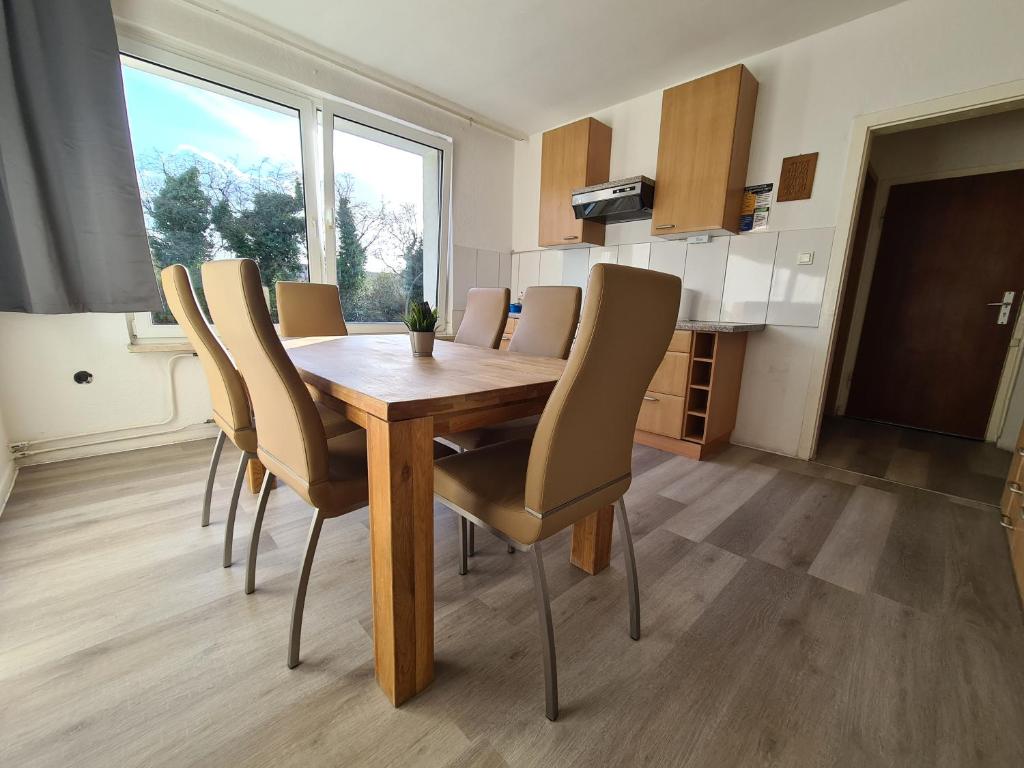 een eetkamer met een houten tafel en stoelen bij B1- Appartements in Bochum