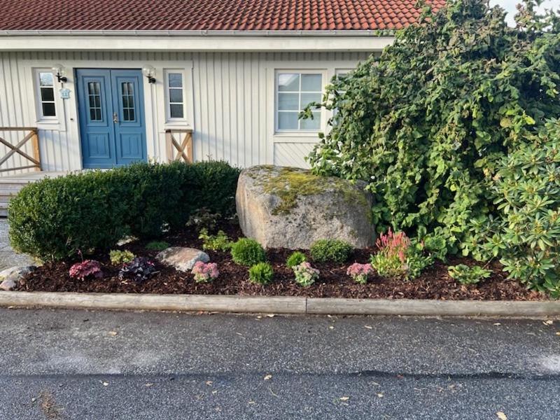 斯特倫斯塔德的住宿－Ronningen Villa，一座带岩石的房子前的花园