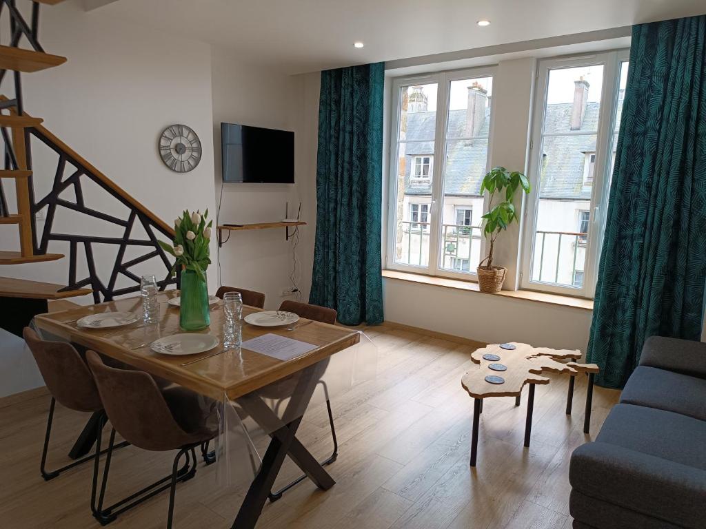 ein Wohnzimmer mit einem Tisch mit Stühlen und einem Sofa in der Unterkunft Beau duplex hyper centre in Coutances