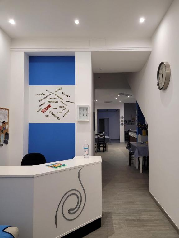 an office with a counter with a clock on the wall at Kristal in Cinisi