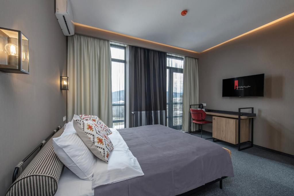 Pokój hotelowy z łóżkiem i biurkiem z telewizorem w obiekcie Almendinger Bolnisi w mieście Bolnisi