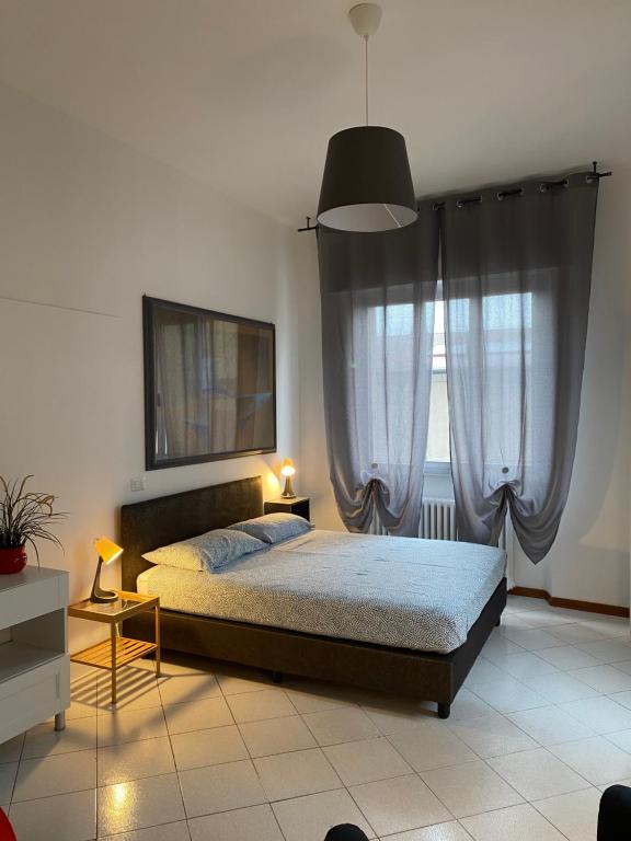 a bedroom with a bed and a large window at Civico 8 in Prato