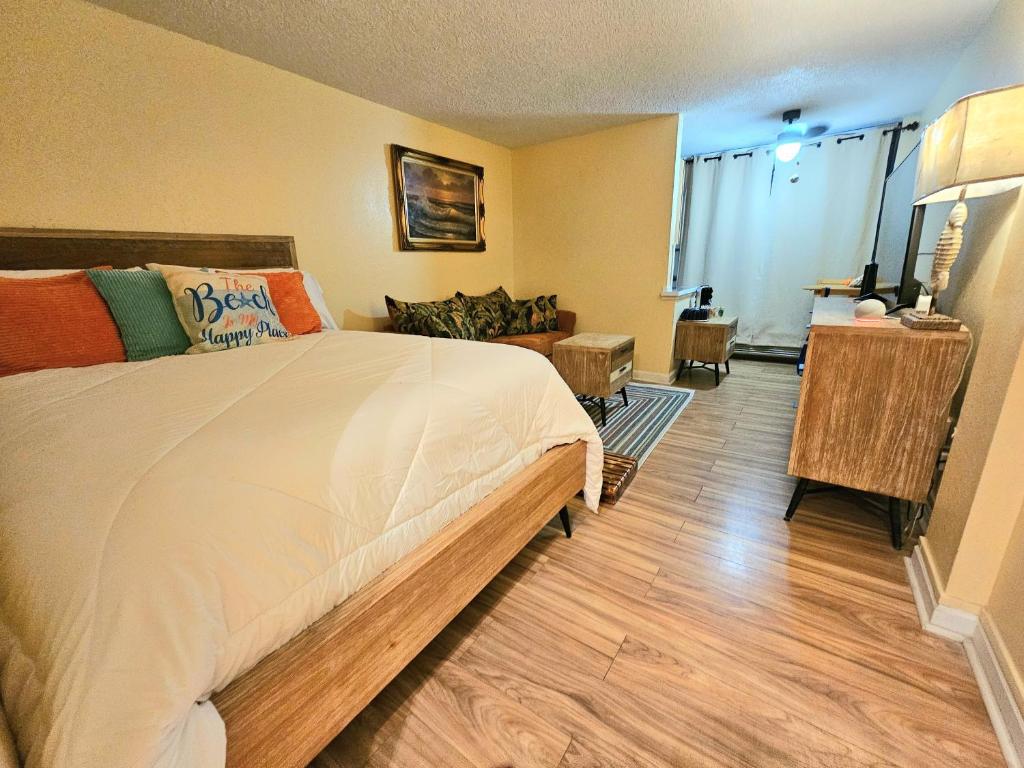 a bedroom with a large bed and a living room at Oceanfront Escape With Balcony and heated salt water pool! in Daytona Beach