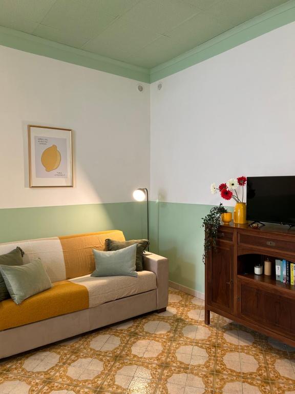 ein Wohnzimmer mit einem Sofa und einem TV in der Unterkunft Casa Maria Rosa - seaside apartment in Sorrent