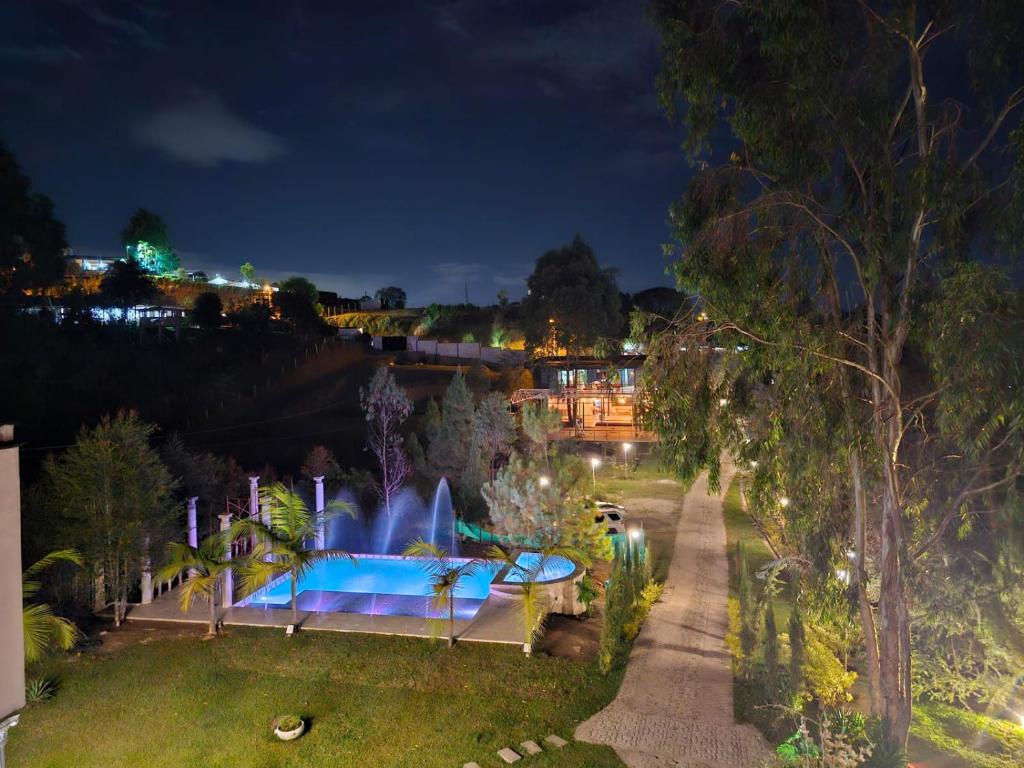 una fuente en medio de un parque por la noche en Hotel Mansión Sant Serrant, en Marinilla