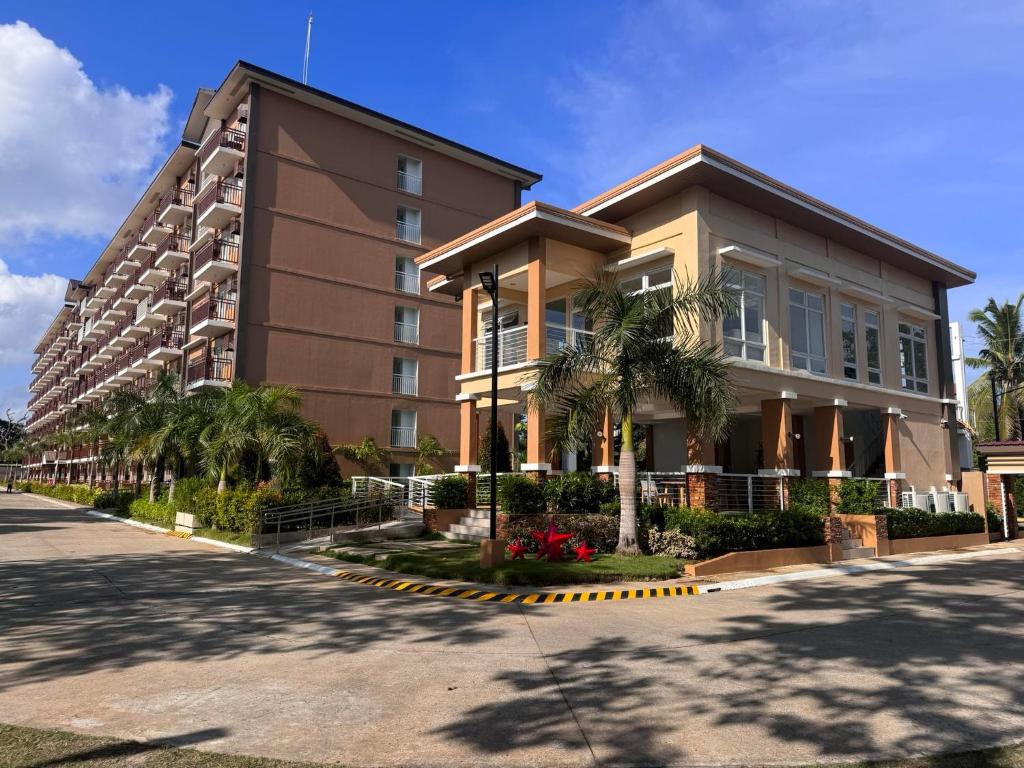 a building with a palm tree in front of it at Cozy Condo Palawan in Puerto Princesa City