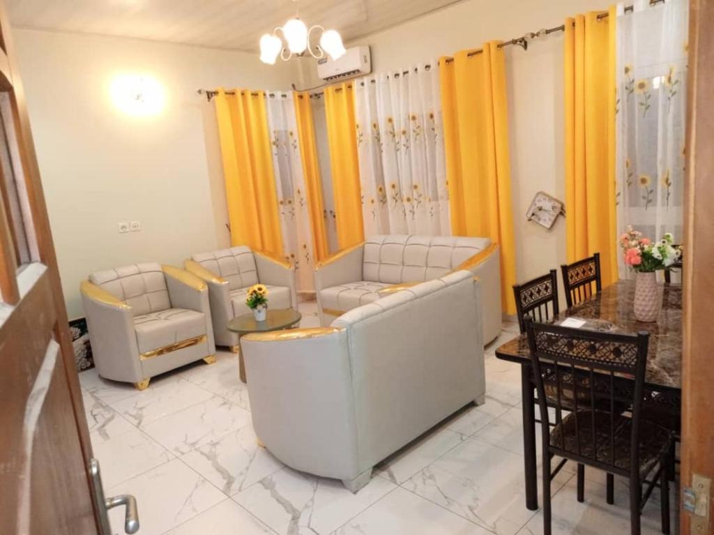 a living room with couches and chairs and a table at RESIDENCE WALNICK in Douala