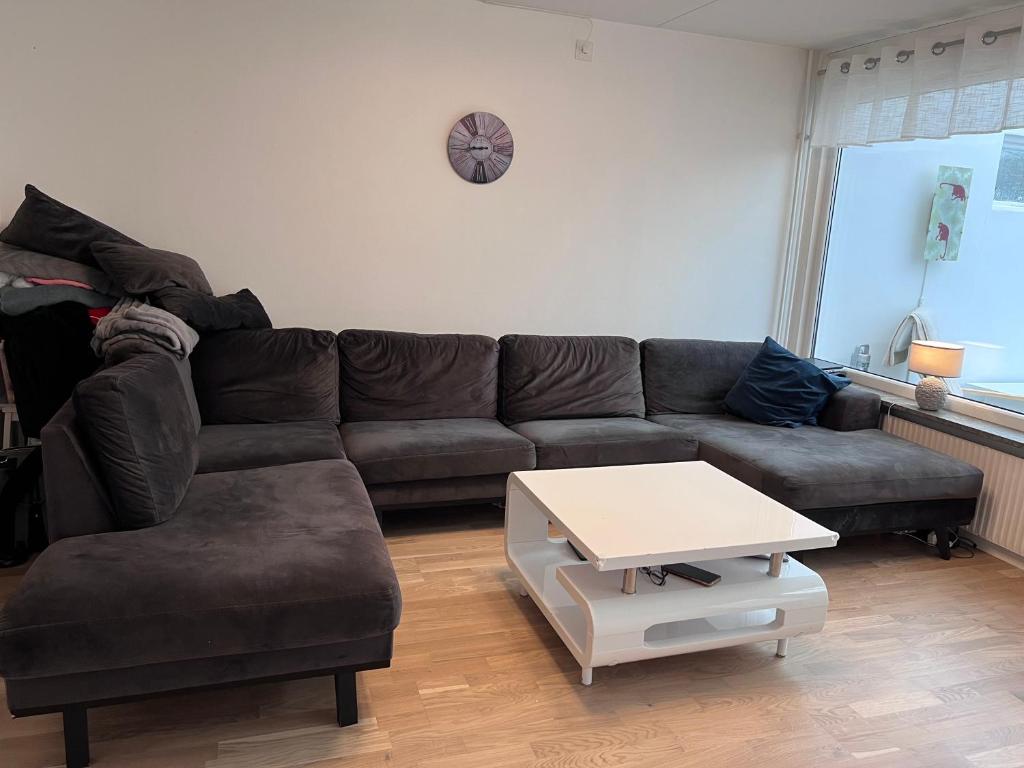 a living room with a brown couch and a table at Rådhus in Bara