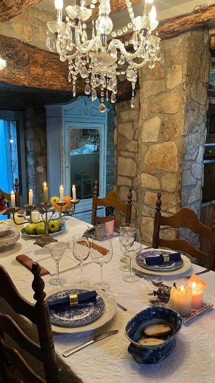 a dining room table with a chandelier and plates and candles at Masiadenjust in Rojals