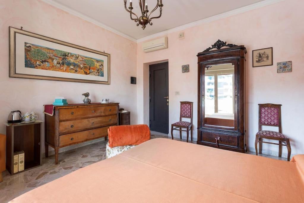 een slaapkamer met een bed, 2 stoelen en een dressoir bij all'ombra del vulcano Etna in Catania