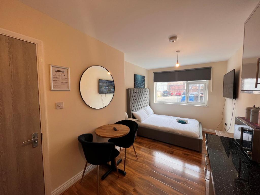 mały pokój z łóżkiem i stołem w obiekcie High-End Central Luton Studio - Ideal for Airport! w Luton