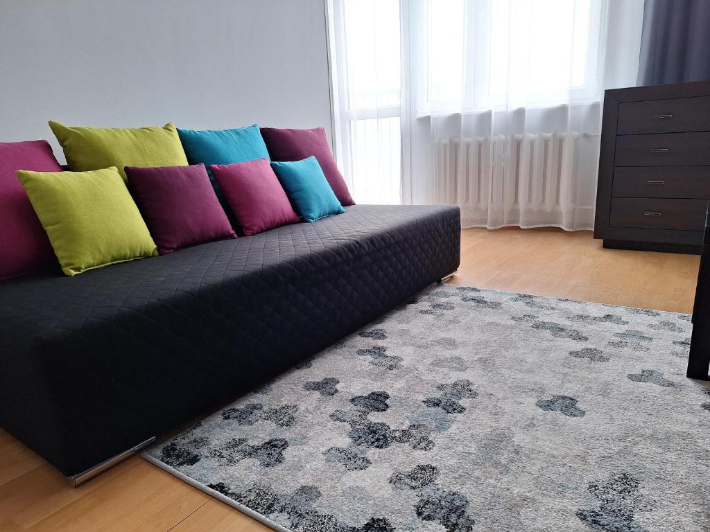 kanapę z kolorowymi poduszkami w salonie w obiekcie Turkusowa Apartament w Szczecinie