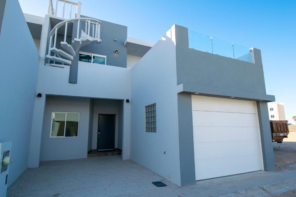 a white house with a garage and a staircase at Residence 35 in Puerto Peñasco