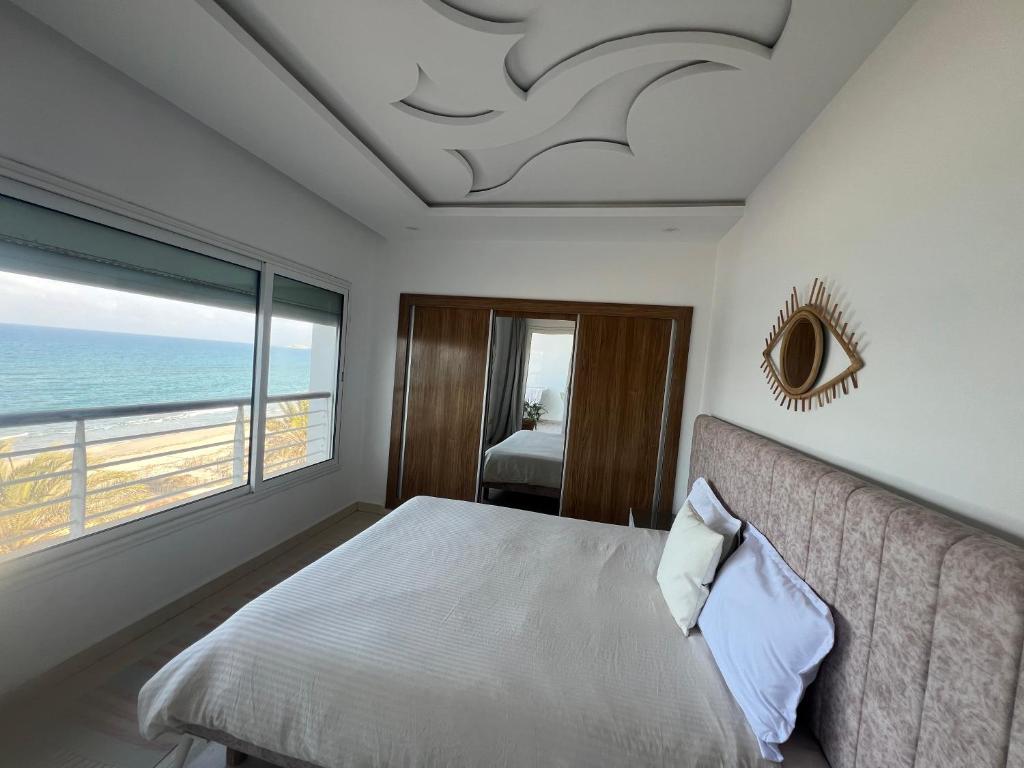 Schlafzimmer mit einem Bett und Meerblick in der Unterkunft Mahdia avec vue sur mer 3 in Hiboun