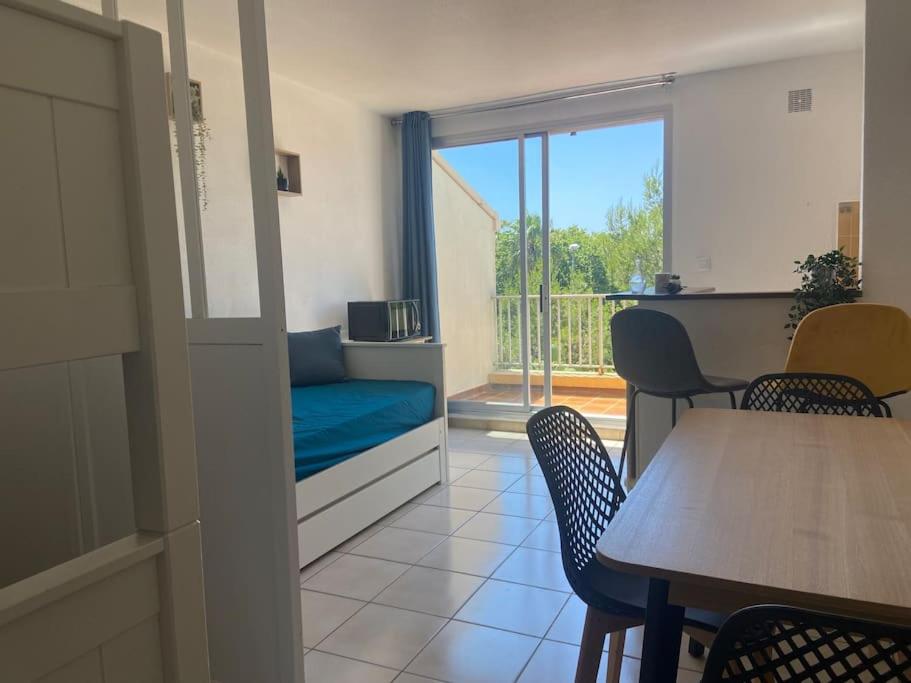 Cette chambre comprend un canapé, une table et des chaises. dans l'établissement Appart 5 min à pied de la plage, au Cap d'Agde