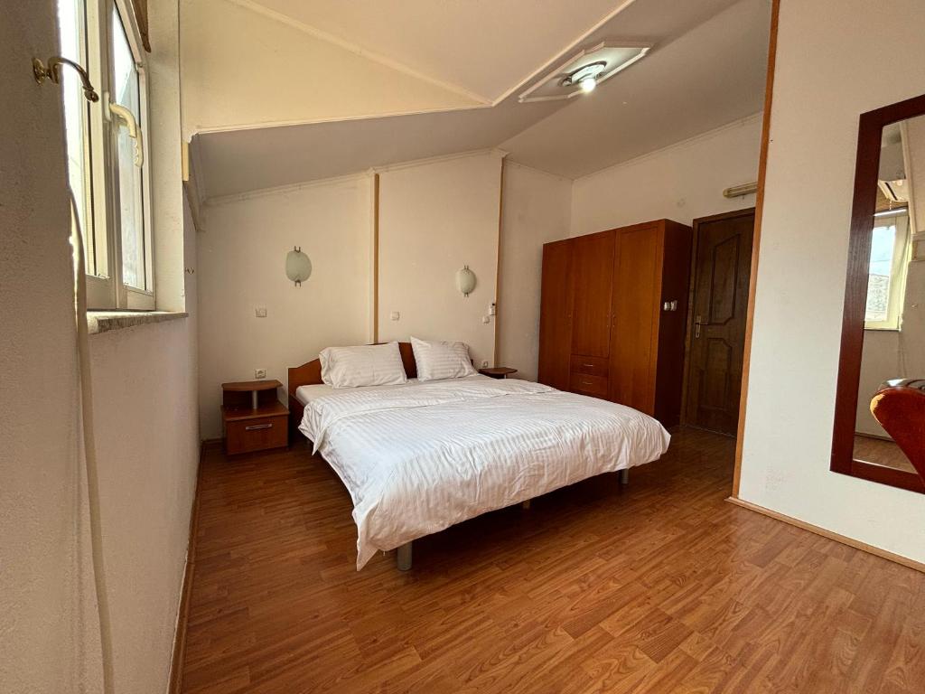 ein Schlafzimmer mit einem großen weißen Bett in einem Zimmer in der Unterkunft Villa KiWi in the Heart of Ohrid in Ohrid