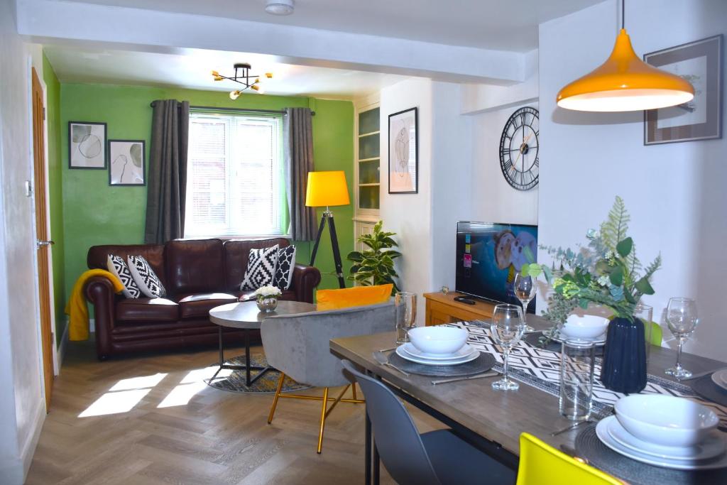 uma sala de estar com uma mesa e um sofá em Bard's Nest Scholars Cottage, Central Stratford, 5 mins walk to RSC em Stratford-upon-Avon