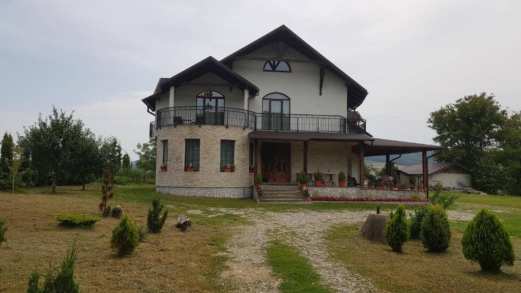 a large house with a balcony on a field at Natura Chalet in Gîlgău