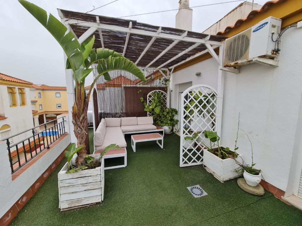 patio con sofá y mesa en el balcón en Atico con gran terraza y barbacoa en Zahara, en Zahara de los Atunes