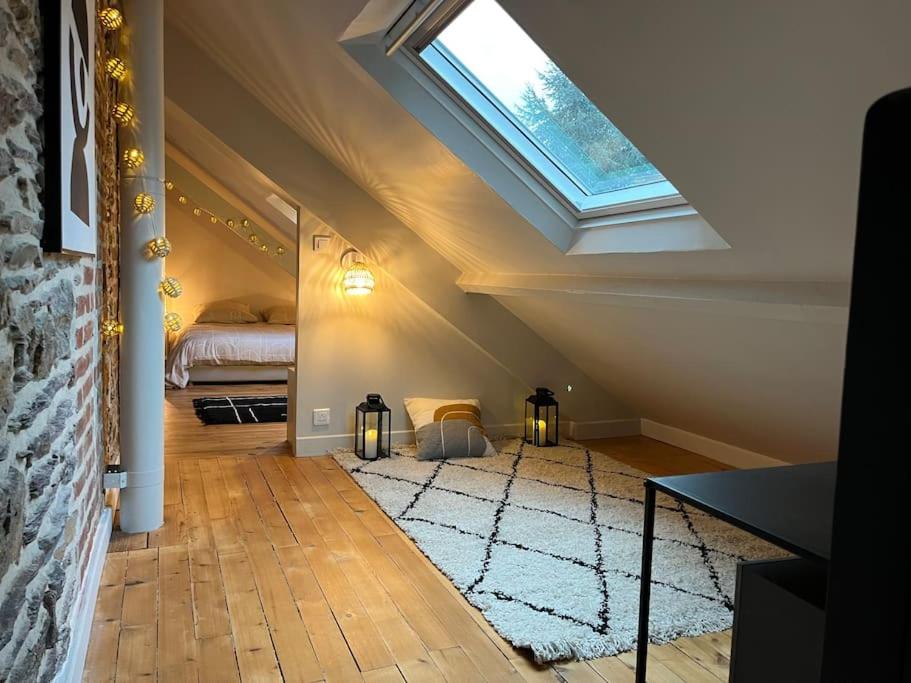 Cette chambre mansardée comprend un lit et une fenêtre. dans l'établissement Ty Thabor - Centre ville au calme 4 pers, à Rennes