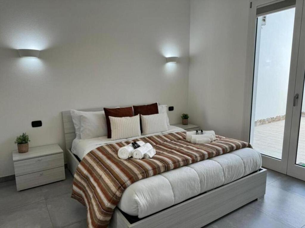 SanluriにあるModerno e Confortevole Appartamento, Wi-Fi e Parcheggio Gratuitoのベッドルーム1室(大型ベッド1台、タオル2枚付)