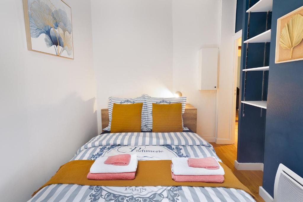 une petite chambre avec un lit avec des serviettes dessus dans l'établissement Guestrust - Arc de Triomphe 46, à Paris