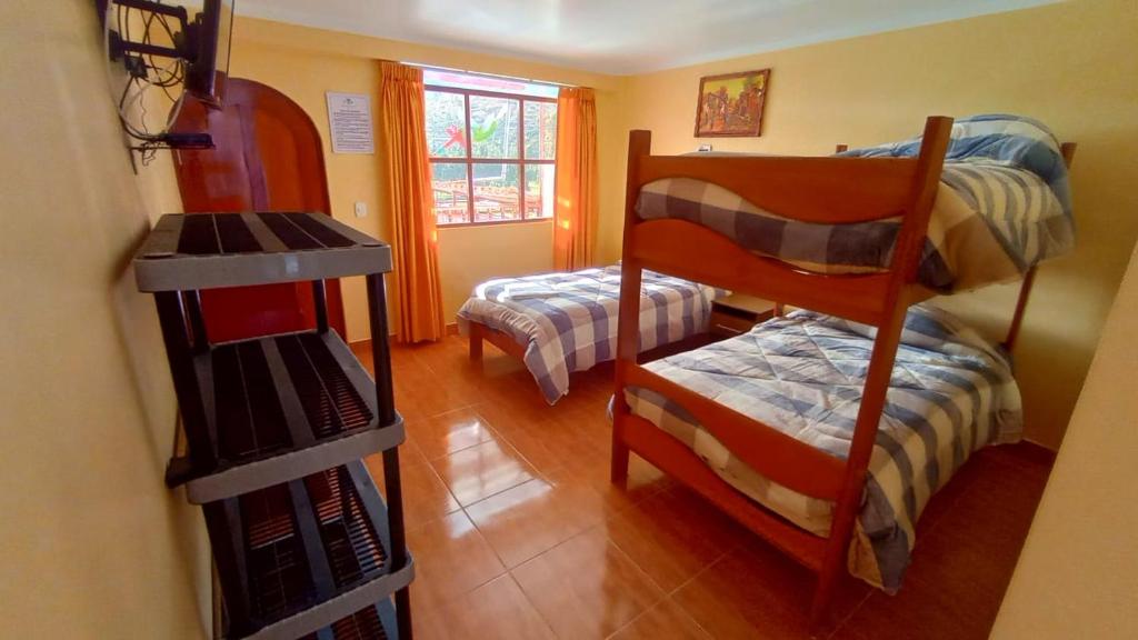 a room with two bunk beds and a book shelf at La Finca Tarma in Tarma